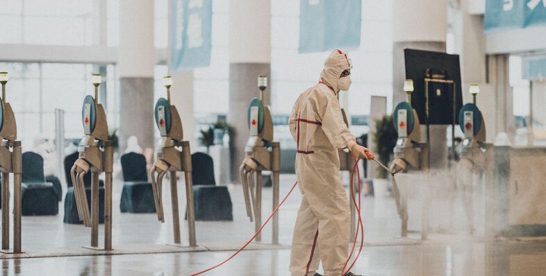 Man spraying down an airport to prevent coronavirus spread