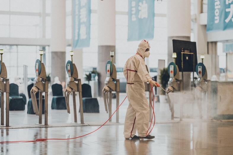 Man spraying down an airport to prevent coronavirus spread