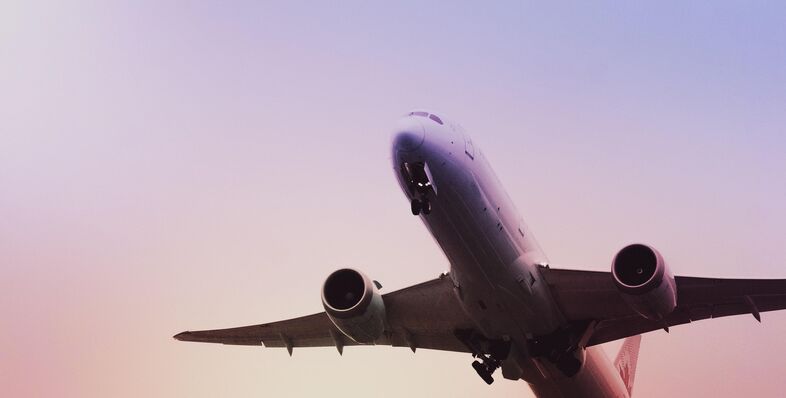 Airplane taking off at sunset