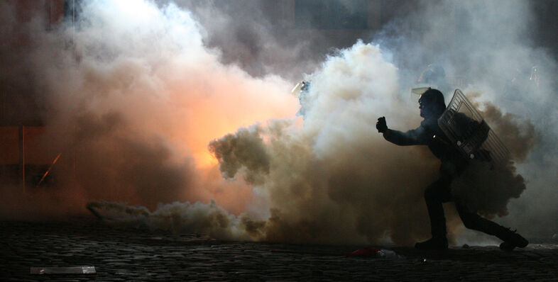 A police officer running through smoke