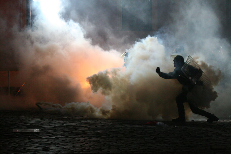 A police officer running through smoke