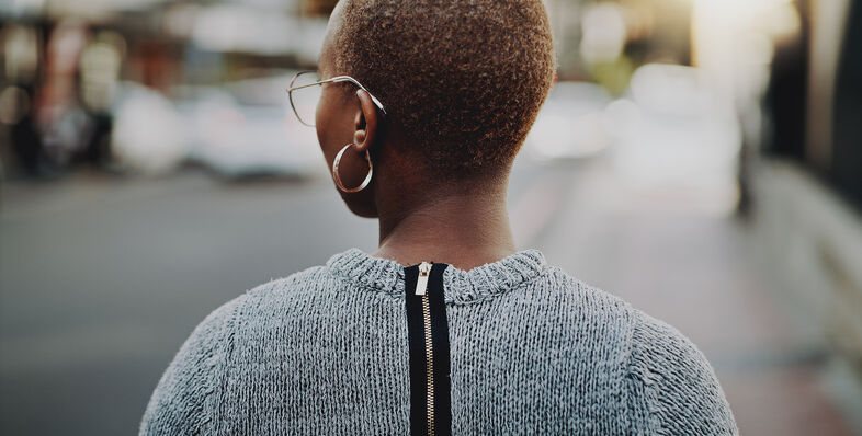 A photo of a woman walking down the sidewalk