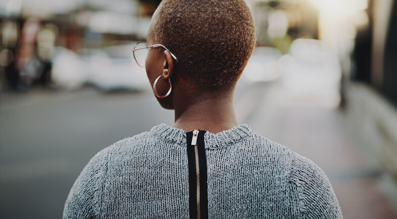 A photo of a woman walking down the sidewalk