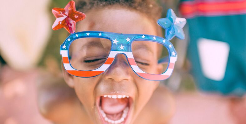 A photo of a young boy wearing American Flag glasses