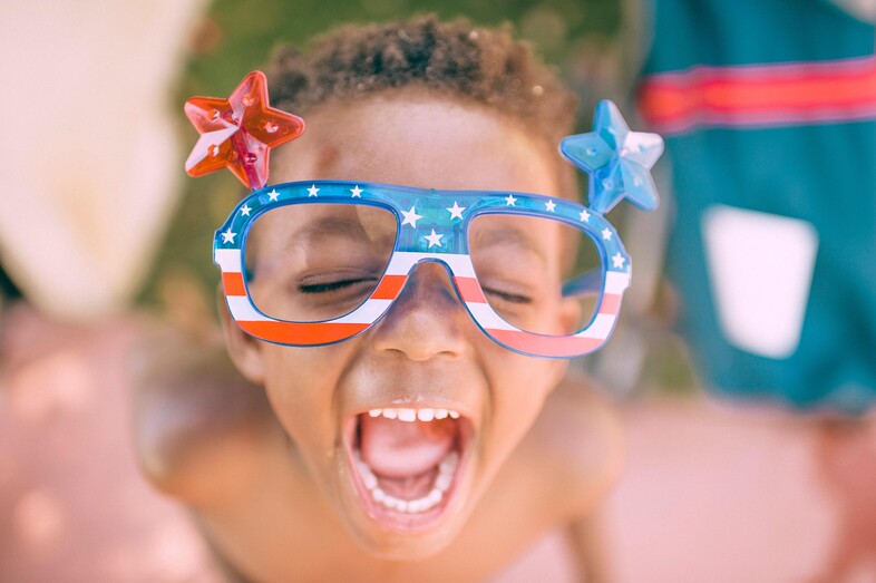 A photo of a young boy wearing American Flag glasses