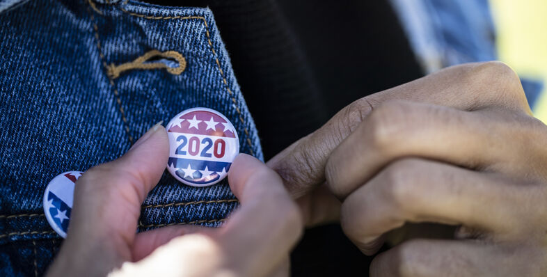 An image of a woman wearing a denim jacket with a 2020 election button