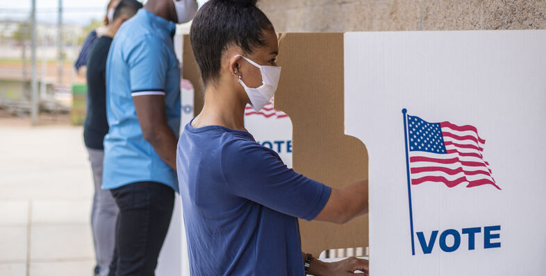 People voting a voting booths in masks