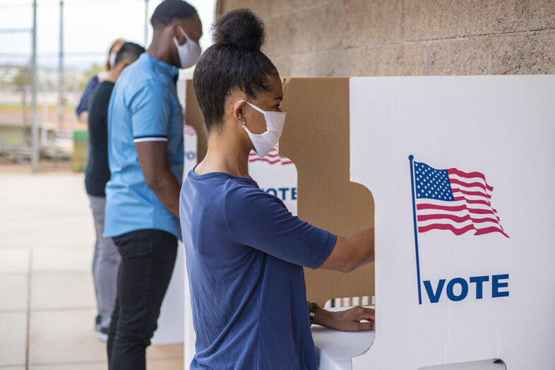 People voting a voting booths in masks