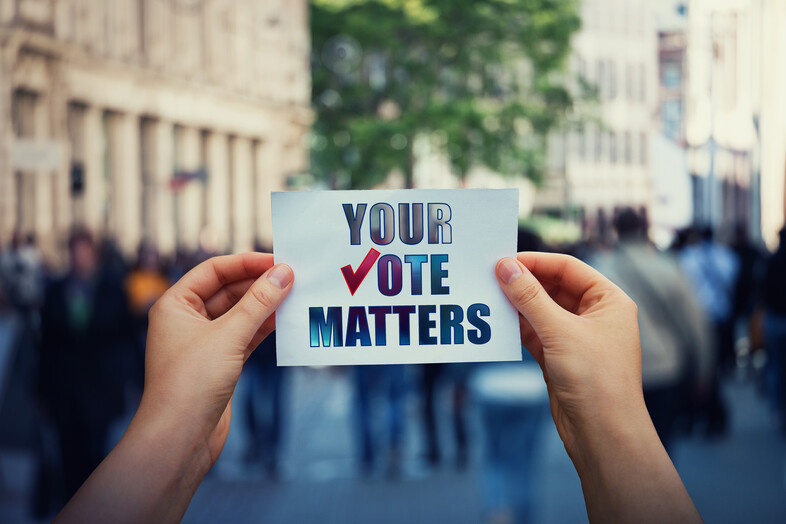 A Person holding a paper that says your vote matters